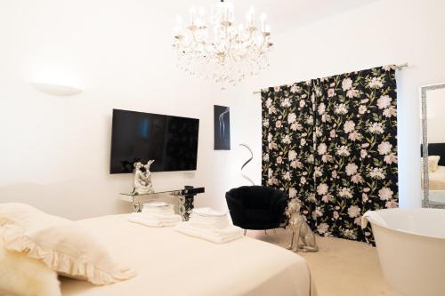 艾因西莱姆The White Knight Premium Boutique Hotel的一间带床和吊灯的卧室以及一间浴室。