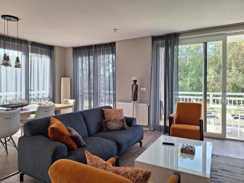 卡德赞德-班得登霍夫公寓的客厅配有蓝色的沙发和桌子