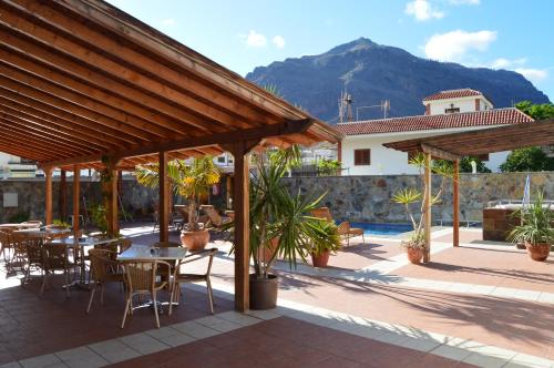 圣尼科拉斯村Hotel La Aldea Suites的一个带桌椅的庭院和山脉