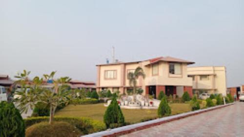 AurangābādGargee Surya Vihar Hotel & Resorts,Hotels and Resorts Aurangabad的一座带花园和街道的大房子