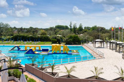 伊索拉阿尔巴勒拉Isola di Albarella Golf Hotel的度假村内带滑梯和游乐设施的大型游泳池