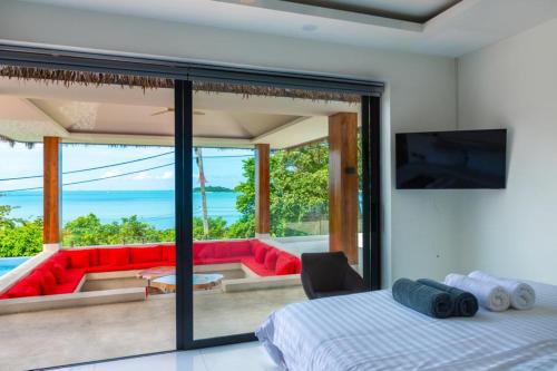 苏梅岛Villa Nirvana - Wonderful Sea View的一间卧室享有带红色沙发的客厅的景色