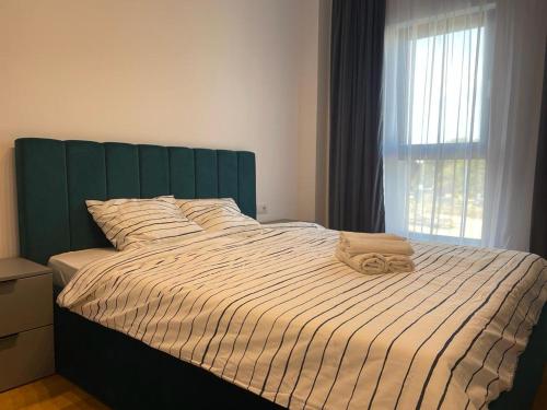 布加勒斯特UpNorth Home的卧室内一张带绿色床头板的床