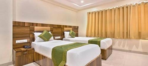 孟买Hotel Mumbai International- Near T2 International Airport的酒店客房设有两张床和窗户。