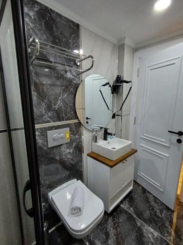 伊斯坦布尔White Palace Hotel的一间带卫生间、水槽和镜子的浴室