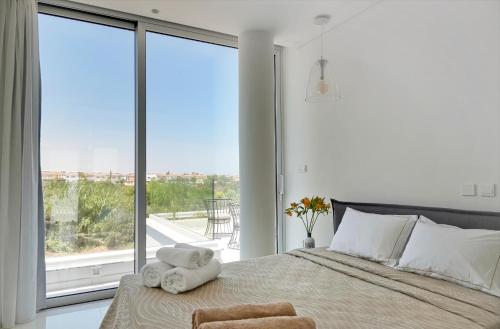 普罗塔拉斯Sunrise Seaview Villas的一间卧室配有一张大床和毛巾