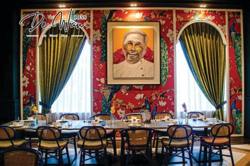 班吉Bangi Resort Hotel的一间设有桌子的用餐室,并展示了一张男人的照片