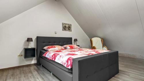 德塞尔An's Vakantiehuisje的一间卧室配有一张黑色床和红色棉被
