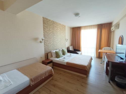 普里莫尔斯科Семеен Хотел Детелини的酒店客房配有两张床和一张书桌