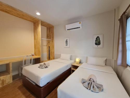 沙美岛Malibu Samed Resort的客房设有两张床和窗户。