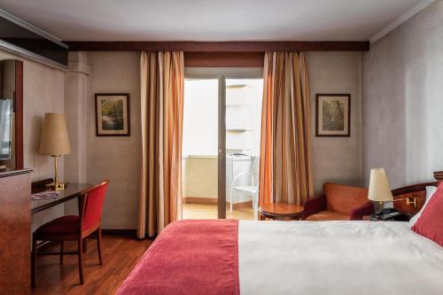 安道尔城ALEGRIA President的酒店客房,配有一张床、一张桌子和椅子