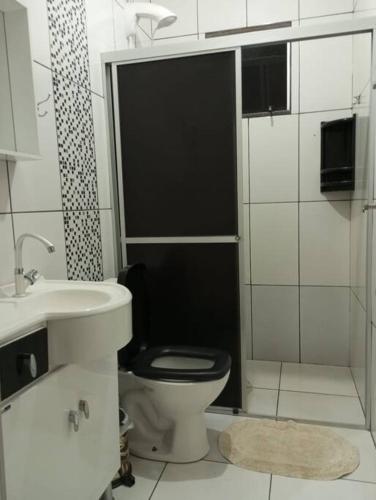 马沙蒂纽Cabana 2 qts com Ar-condicionado的浴室设有黑色的卫生间和水槽。