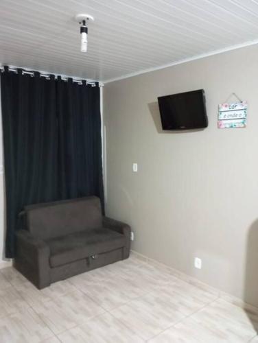 马沙蒂纽Cabana 2 qts com Ar-condicionado的一间配有沙发和墙上电视的客房