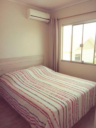 马沙蒂纽Cabana 2 qts com Ar-condicionado的一间卧室配有一张床,床上有条纹毯子
