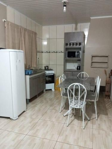 马沙蒂纽Cabana 2 qts com Ar-condicionado的厨房配有桌椅和冰箱。