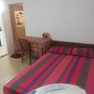 贾夫纳Nallur Mylooran Arangam的卧室配有一张床和一张桌子
