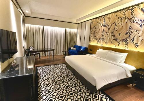 班吉Bangi Resort Hotel的一间卧室配有一张床、一张桌子和一台电视。