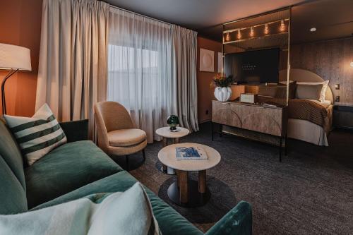 朗伊尔城方垦小屋酒店的酒店客房设有一张沙发和一张床