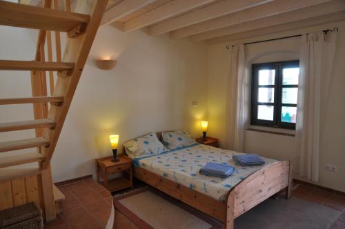 塔维拉Fazendinha - Tavira - Spacious and tranquil的一间卧室配有一张带两盏灯和梯子的床。