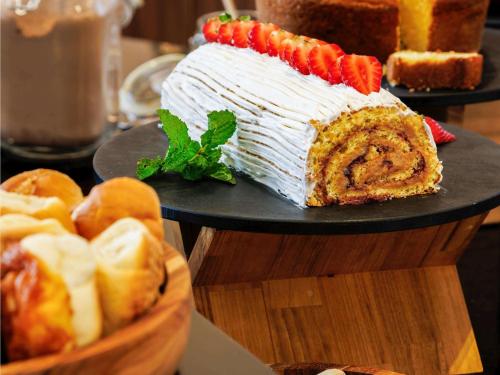 贝洛奥里藏特宜必思贝洛奥里藏特利贝尔达德酒店的桌上的大蛋糕和一篮面包