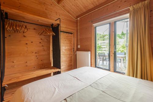 赞德沃特Chalet Zandvoort的一间卧室设有一张大床和一个窗户。