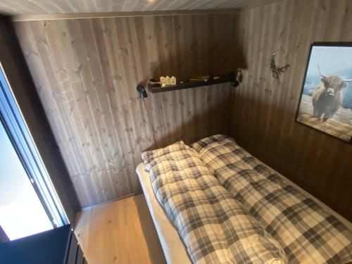 SaudaModerne hytte i Svandalen, Sauda - nær skisenter og natur的一张小床,房间带一条铺着地毯的毯子