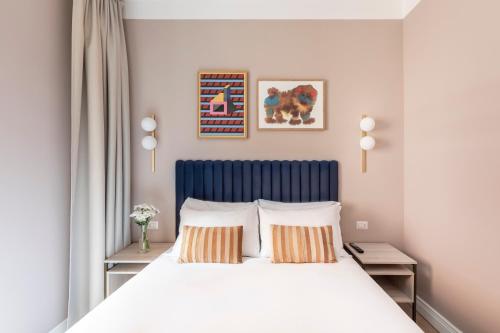 罗马numa I Linea的一间卧室配有一张带蓝色床头板的床和两个枕头