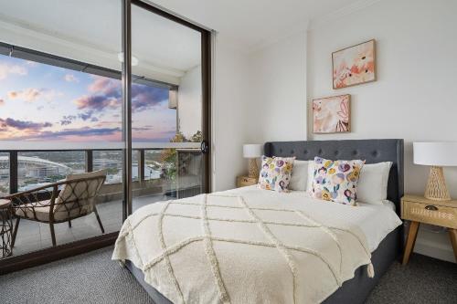 悉尼The Sky Garden的一间带大床的卧室和一个阳台