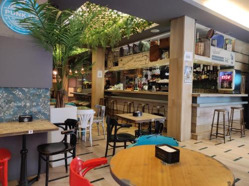 托莱多托莱多绿洲背包客旅馆的一间带桌椅的餐厅和一间酒吧
