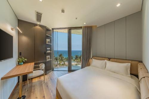 岘港Taiyo Hotel & Apartment的一间卧室配有一张床,享有海景