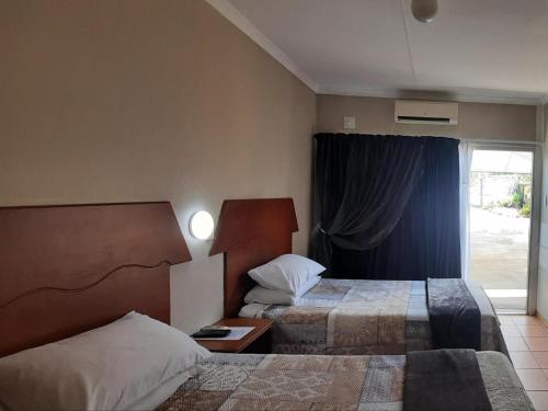 库鲁曼Kalahari Kaja的酒店客房设有两张床和窗户。