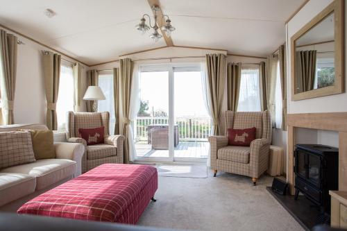 Saint HelensSt Helens Coastal Resort的客厅配有沙发、椅子和壁炉