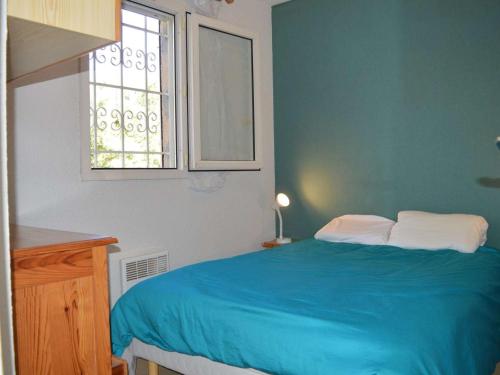 拉克鲁瓦瓦尔梅Appartement La Croix-Valmer, 2 pièces, 4 personnes - FR-1-226B-28的一间卧室设有蓝色的床和窗户。