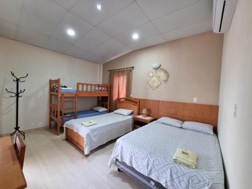 Villa ConcepciónHotel Karanda´y的一间卧室配有两张床和一张双层床。