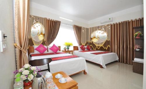 宁平TAMCOC VUTHANH FRIENDLY Hotel的酒店客房设有两张床和一张桌子。