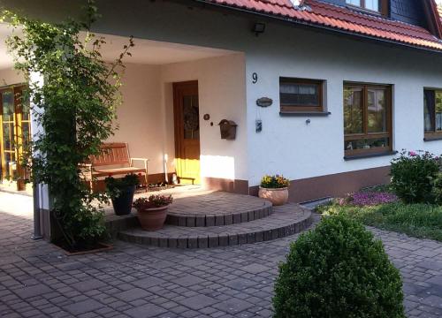 HerscheidKomfort Ferienwohnung的房屋设有砖砌庭院,上面设有长凳