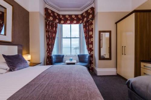 兰迪德诺Lauriston & Lawton Court Hotel的一间设有大床和窗户的酒店客房