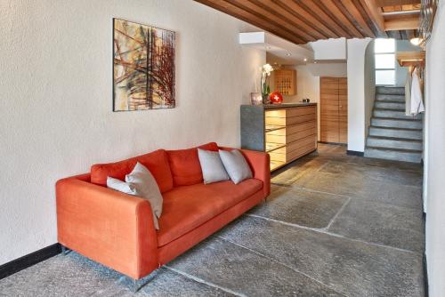 圣贝纳迪诺贝勒维酒店的客厅里设有橙色沙发,设有楼梯