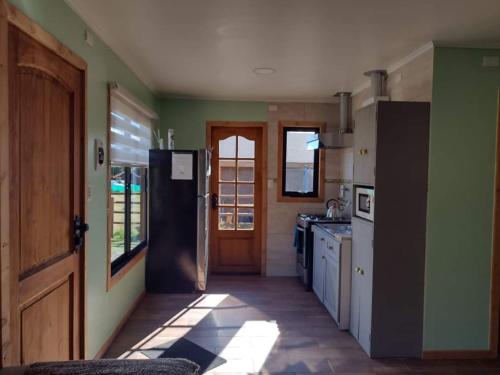 科伊艾科Turismo El Embrujo的厨房设有绿色的墙壁和黑色的冰箱。