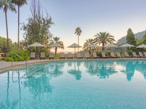 德阿埃斯莫里酒店的一个带椅子和遮阳伞的大型游泳池