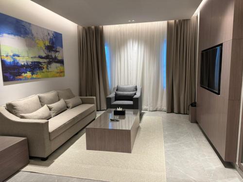 利雅德الحزم للشقق الفندقية - الرياض - العليا的带沙发和电视的客厅
