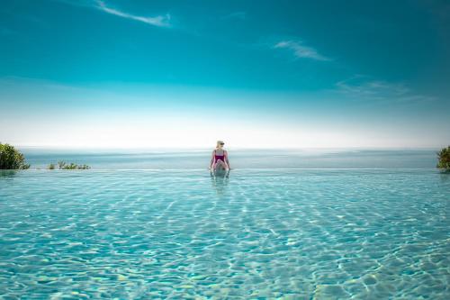 圣凯撒利亚温泉Le Capase Resort Salento的站在海洋水中的女人