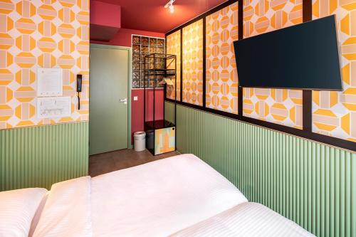 阿姆斯特丹经济型旅游酒店的一间卧室配有一张床和一台平面电视