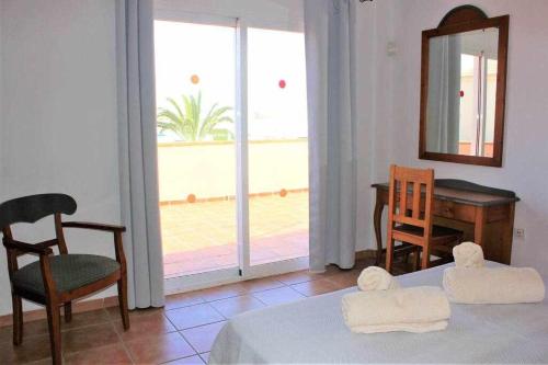 科拉雷侯CASA MARTA duplex con piscina privada en Corralejo的客房设有床、桌子和镜子