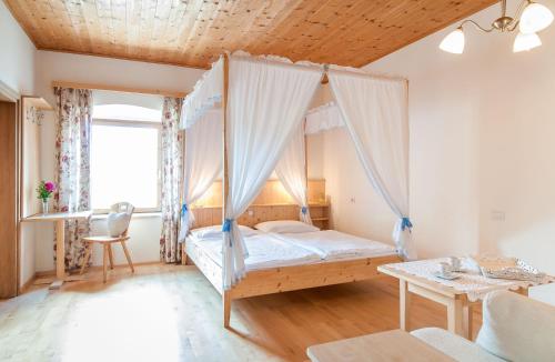 拉伊翁Garni Tschutscherhof的一间卧室配有一张带天蓬的床