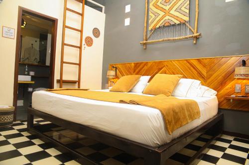 圣玛尔塔Masaya Santa Marta的一间卧室配有一张大床和木制床头板