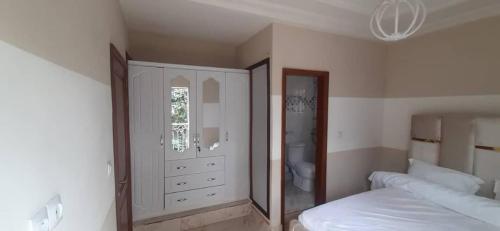 雅温得KDN Sweet Home Meublés的一间卧室配有一张床和一面大镜子