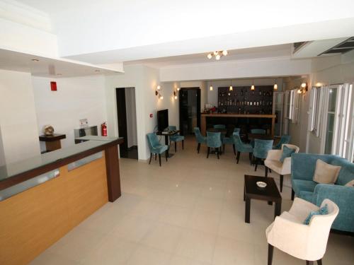 阿约斯尼奇塔斯Ionis Hotel的一间设有蓝色椅子的等候室和一间酒吧