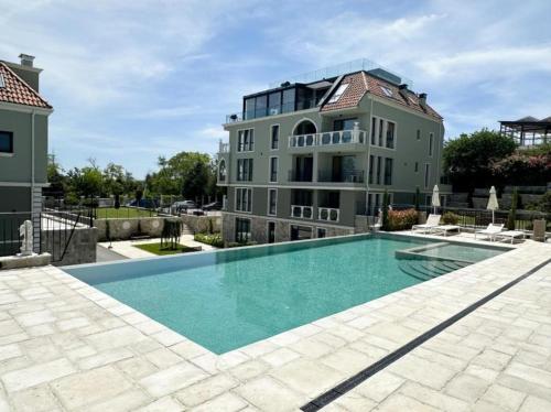 瓦尔纳LUXURY APARTMENT in Mediterranea VARNA Complex, sea view and Infinity pool的一座大房子,前面设有一个游泳池