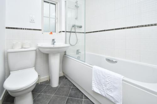 莱姆河下游的纽卡尔斯Tansey House by YourStays的浴室配有卫生间、盥洗盆和浴缸。